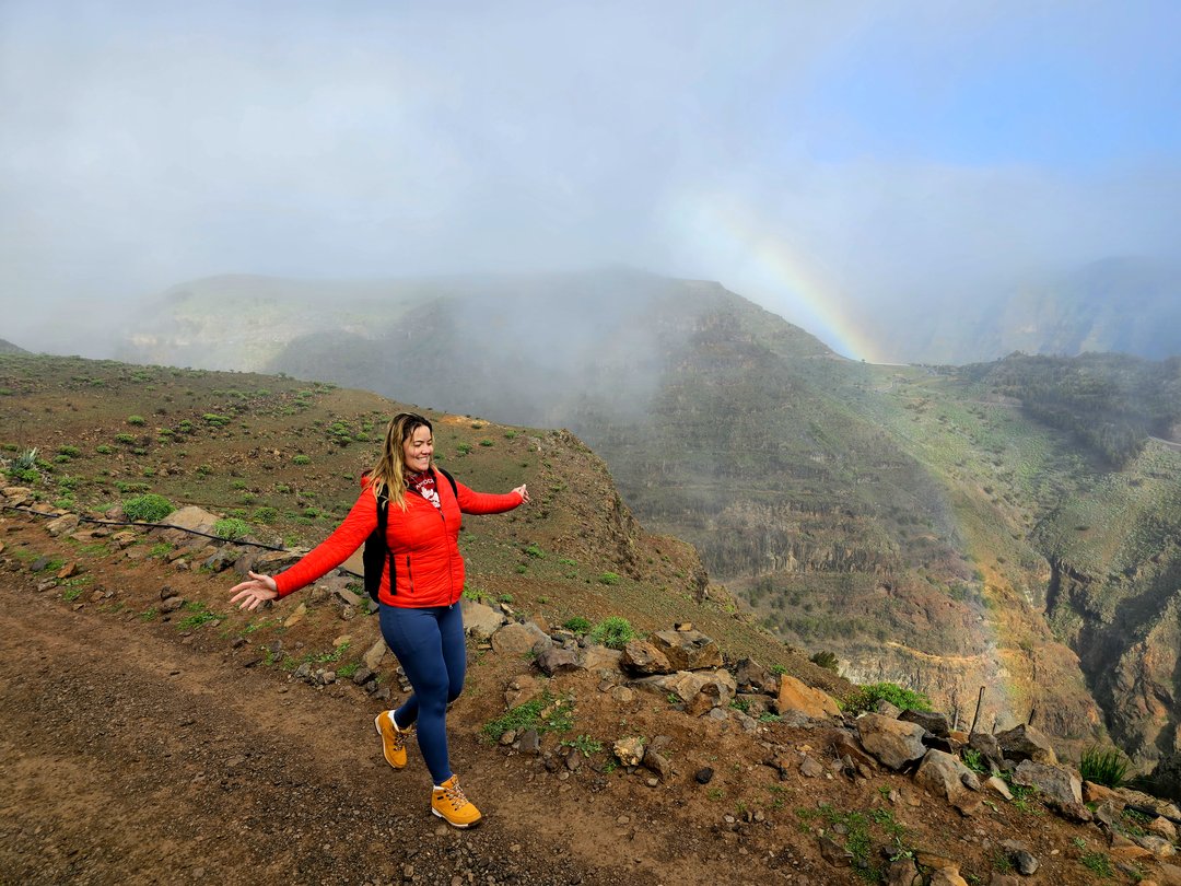 Woman meditating on a cliff overlooking the ocean in La Gomera