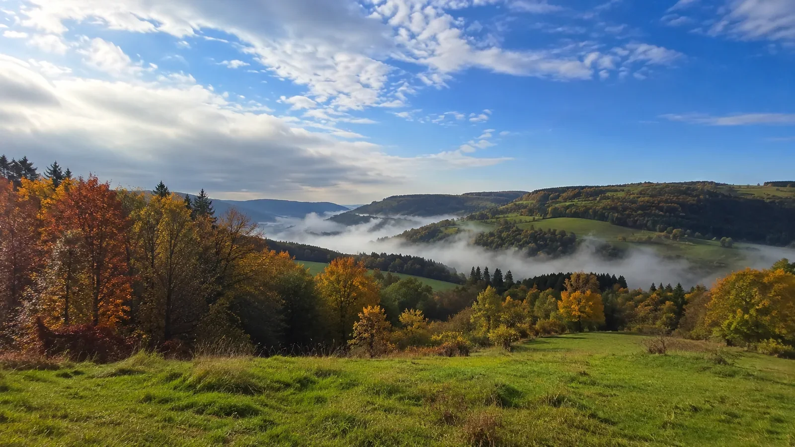 An open autumn valley with mist between the hills