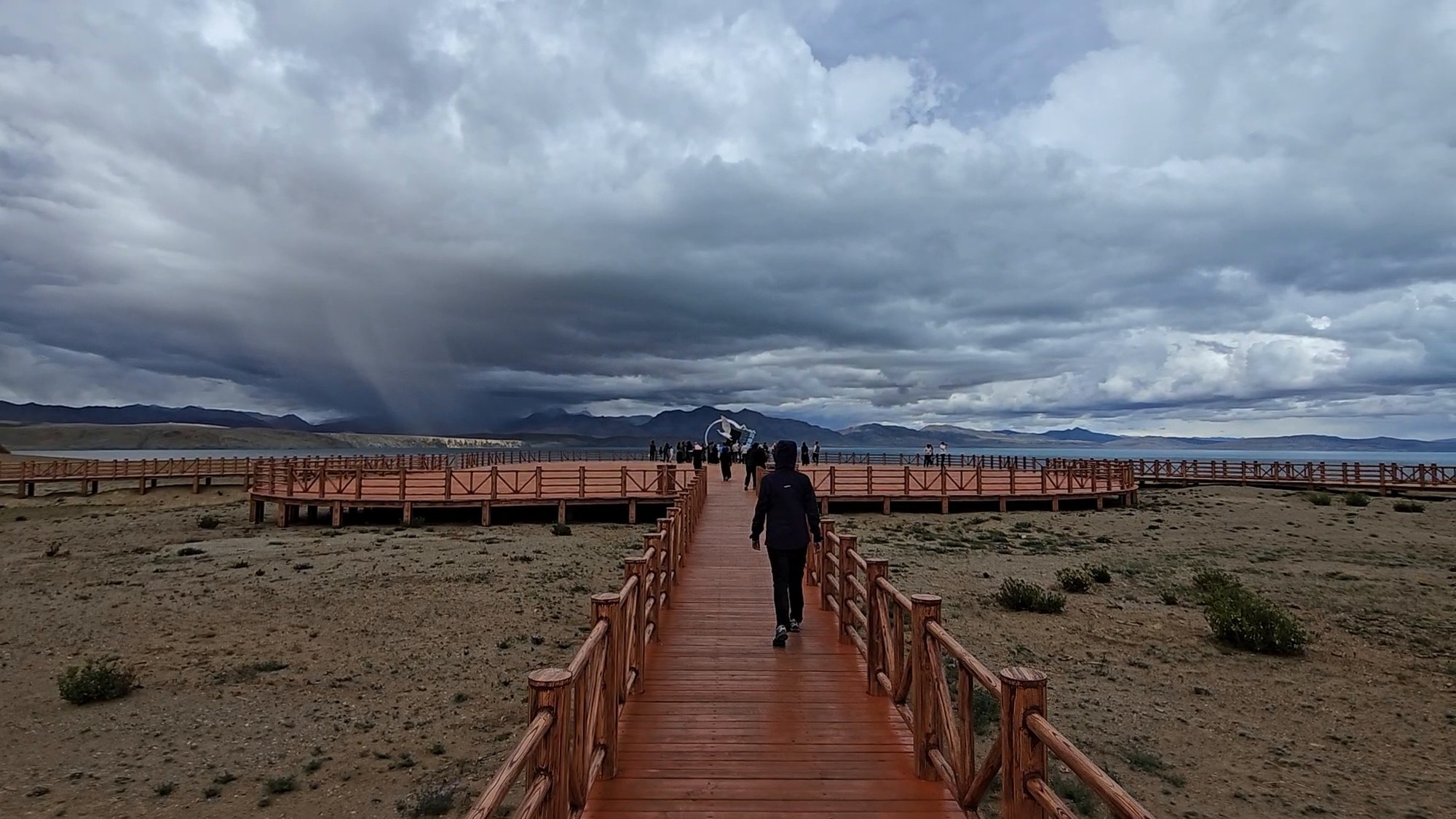 A solitary path beneath a vast changing sky in Tibet